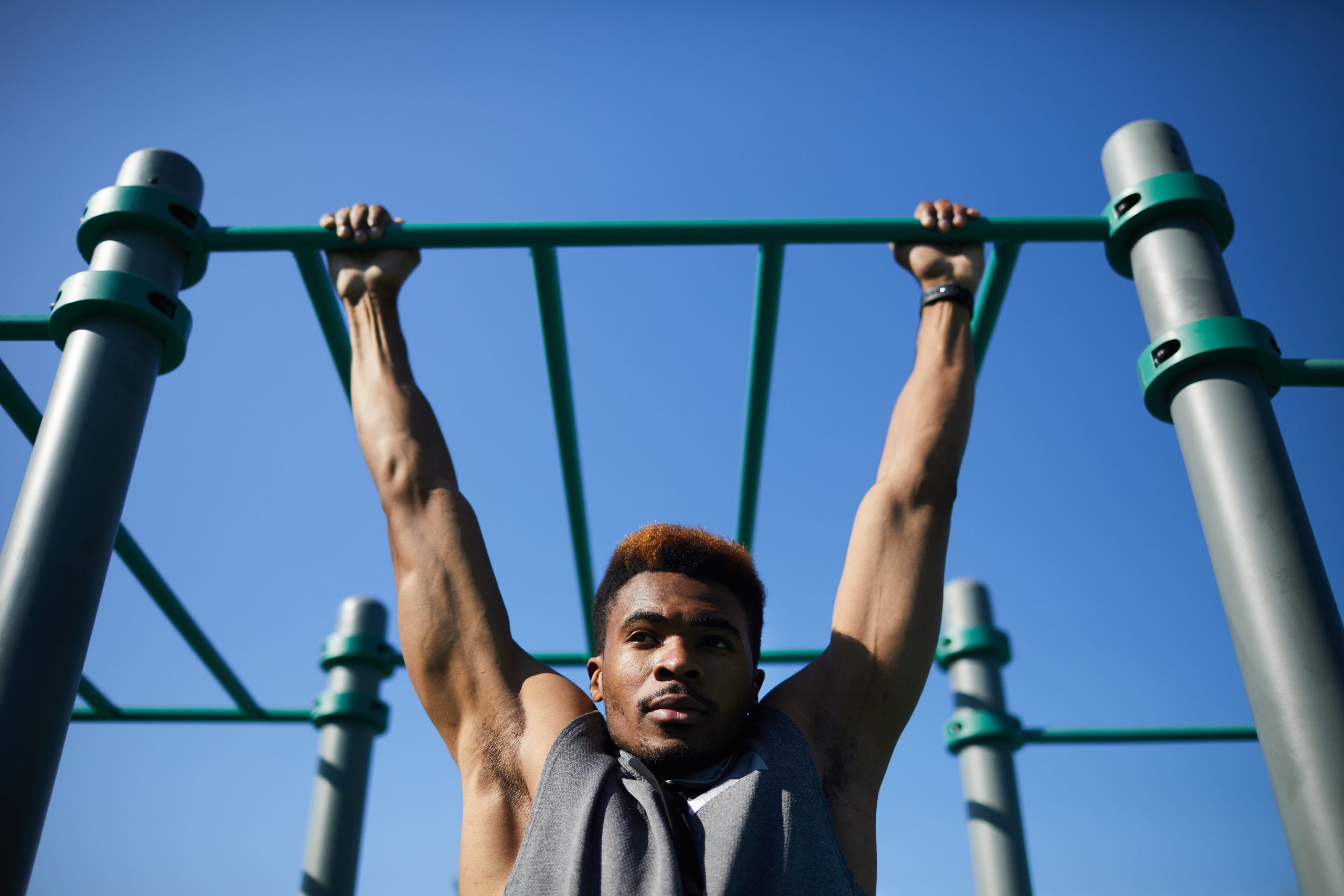 Black man doing pull-up on bar